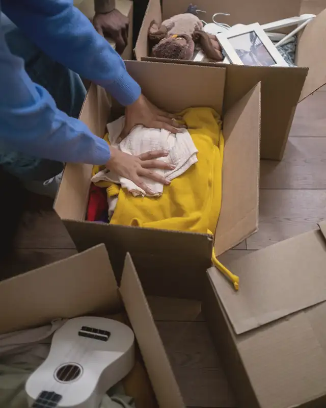Clothing being packed into a cardboard box
